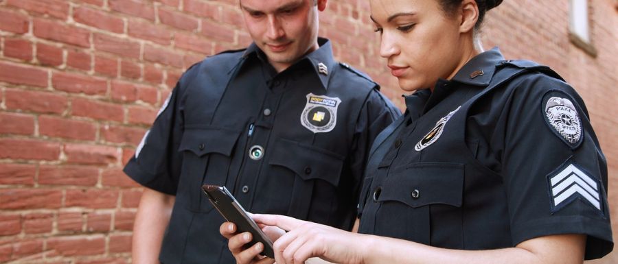 two security guard looking at a phone
